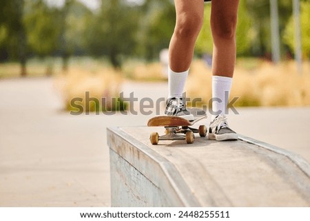 A young African American woman skateboarding on a ledge at an outdoor skate park.
