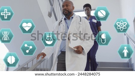 Image of medical icons over african american female and male doctor rushing down staircase. Medical and healthcare services concept digitally generated image.