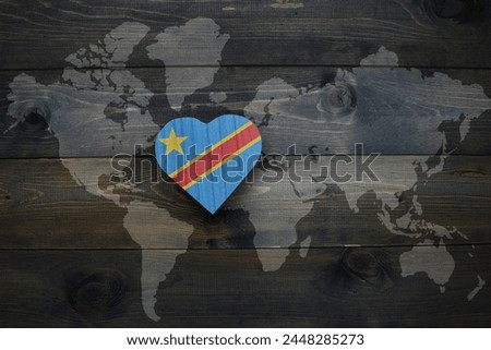 wooden heart with national flag of democratic republic of the congo near world map on the wooden background. concept