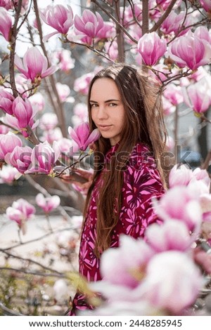 Young woman in the park near a magnolia tree.
