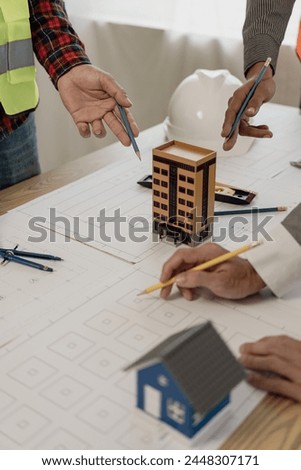 Pictures of architecture project engineer meeting Collaborate with partners and engineering tools and point at drawings to discuss. Engineering tools and construction concepts vertical picture