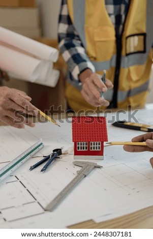 Pictures of architecture project engineer meeting Collaborate with partners and engineering tools and point at drawings to discuss. Engineering tools and construction concepts vertical picture
