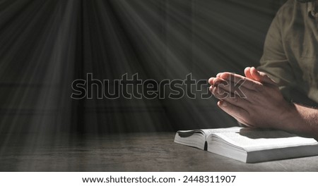 Religion. Christian man praying over Bible at table, closeup. Banner design