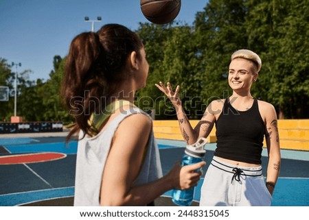 A young woman stands confidently in front of a basketball on a sunny outdoor court.