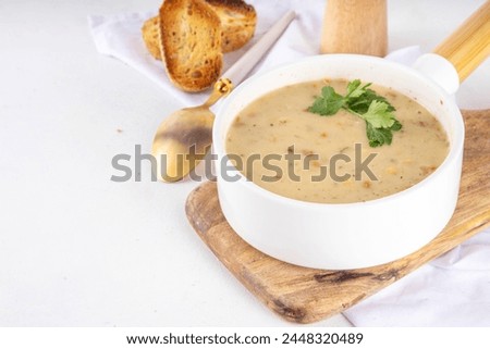 Thick vegan cream soup. Homemade golden yellow cream soup with herbs and croutons toast bread. Cheese, chicken, bean, corn cream soup in a plate on a white kitchen table copy space