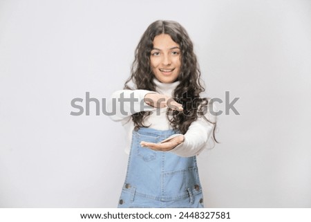 Pretty Pakistani woman holding something invisible and big in her palms, Girl has clear skin and strong wavy hair, copy space area on white background