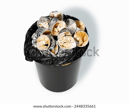 Sideview a trash bin filled with used paper cups, showing people drink too much coffee. They cost health issue and considering more sustainable option to minimize waste of single -use produtcs.  Royalty-Free Stock Photo #2448335661