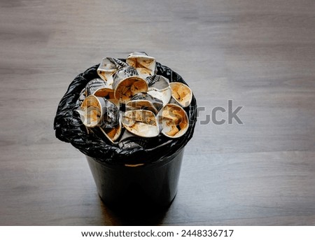 Top view a trash bin filled with used paper cups, showing people drink too much coffee. They cost health issue and considering more sustainable option to minimize waste of single -use produtcs. Royalty-Free Stock Photo #2448336717
