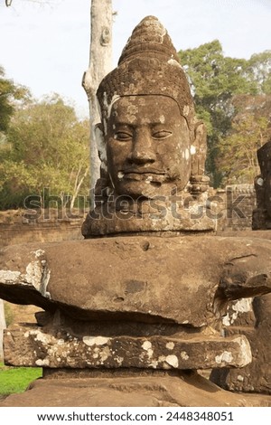 A deva faces on le left side of the causeway that spans the moat in front of Angkor Thom South gate, Siem Reap, Cambodia.  