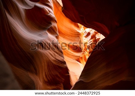 Colorful sandstone formations in a slot canyon, a natural attraction in Arizona USA. Gently eroded rock forms imaginative shapes and plays of light and shadow in shades of red, orange, brown, yellow Royalty-Free Stock Photo #2448372925
