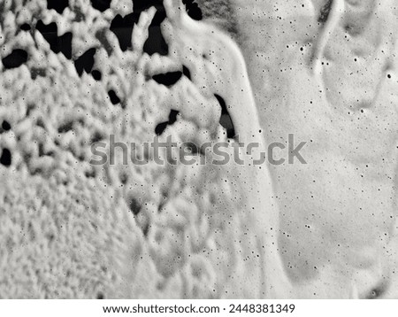 Washing car with foam. Foam bubble and water drop on car texture background. Washing black car with active foam