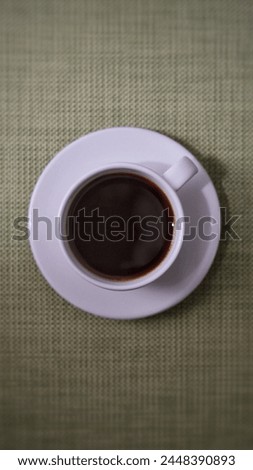 black coffee served in a white cup and saucer from view from up top to start the morning right
