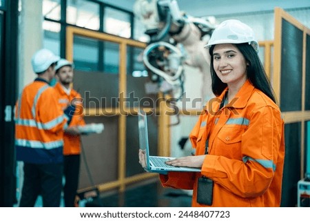 A group of Robotics engineers working with Programming and Manipulating Robot Hand, Industrial Robotics Design, High Tech Facility, Modern Machine Learning. Mass Production Automatics. Royalty-Free Stock Photo #2448407723