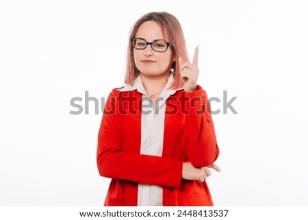 Serious Young Woman in Red Blazer Raises Finger, Commanding Attention and Demanding Focus. Concept of a Authority, Leadership, and the Power of Expression Royalty-Free Stock Photo #2448413537