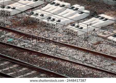 An overhead view reveals discarded railway sleepers and rusted tracks, painting a picture of forgotten infrastructure slowly being reclaimed by nature.