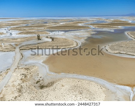 Drone view of dead salt lake Tuz in Turkey. Landscape is like on Moon or Mars, everything dried covered with salt. Here, edible salt is extracted and processed in factory or factory. Alien landscape. Royalty-Free Stock Photo #2448427317