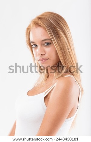 Close-up of a contemplative young woman with striking blonde hair, white background