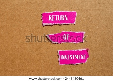 Return of investment words written on ripped paper pieces with cardboard background. Conceptual business symbol. Copy space.