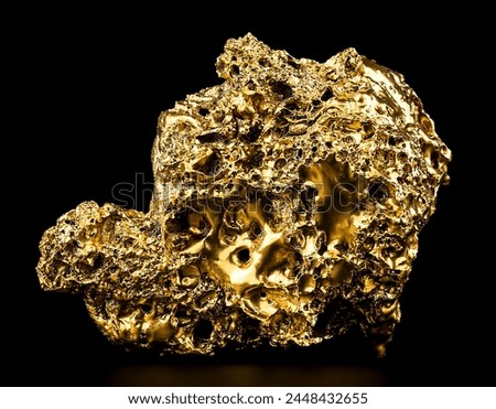 Pure gold from the mine on black background. Closeup of gold nugget. Finance and business concept.