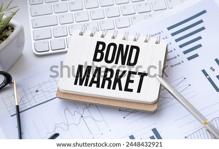 Bond Market text, written on sticker with calculator, pen on chart background. Investment Portfolio