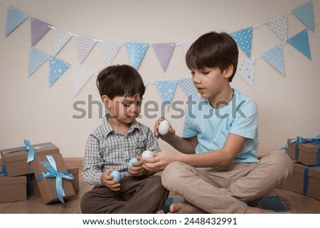 Children play with Easter eggs and laugh.Easter photo shoot in the studio.Cheerful children smiling and laughing
