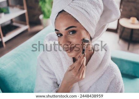 Photo portrait of lovely young lady roller massager liftup tool face wrapped towel dressed bath robe treatment personal care home concept