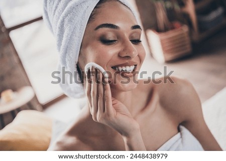 Photo portrait of attractive young woman hold cotton sponge apply dermatology cosmetics wrapped towel home interior enjoy weekend