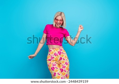 Photo portrait of attractive young woman sunglass dancing good mood dressed stylish pink clothes isolated on blue color background