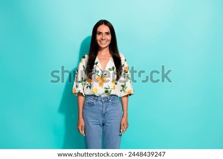 Photo of gorgeous good mood woman with long hairstyle dressed flower print blouse standing smiling isolated on turquoise color background