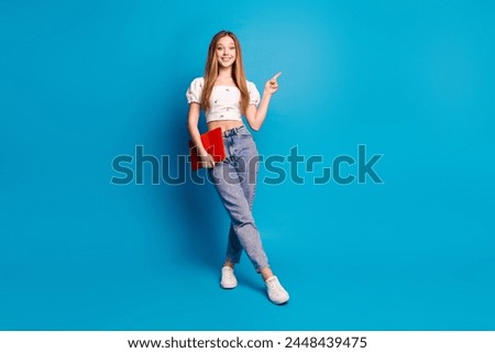 Photo of happy positive girl hold netbook point demonstrate empty space isolated blue color background