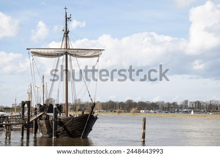 Replica of an old merchant ship -Kamper Kogge, along the river IJssel near the Dutch historic Hanseatic city of Kampen in Overijssel. Royalty-Free Stock Photo #2448443993
