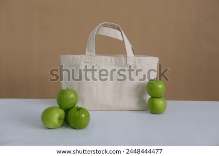 Tote bag with fruits, apple, lemon, baguette  bakery as props for mock-up, perfect for showcasing your design or branding identity in a creative and vibrant composition