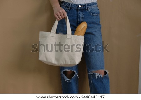 Side view mock-up of a tote bag with vibrant fruits, apple, lemon, and baguette bakery, hand holding, perfect for showcasing your design or branding identity in a creative and vibrant cafe composition