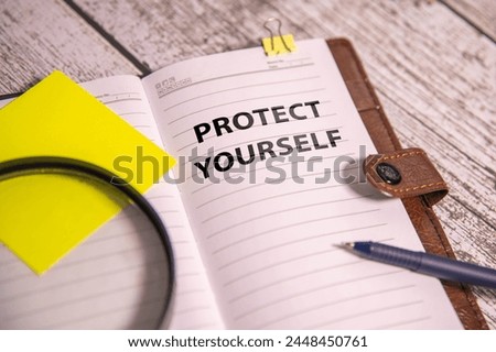 PROTECT YOURSELF text written on yellow paper with notebook. Royalty-Free Stock Photo #2448450761