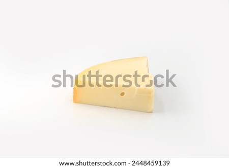 wedge slice of typical Italian spicy provolone cheese on isolated white background Royalty-Free Stock Photo #2448459139