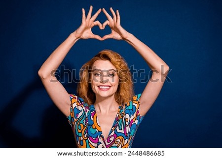 Portrait of lovely cheerful woman dressed trendy clothes arms showing heart figure isolated on dark blue color background