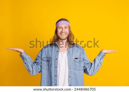 Photo portrait of attractive young hippie man compare empty space wear trendy denim outfit isolated on yellow color background