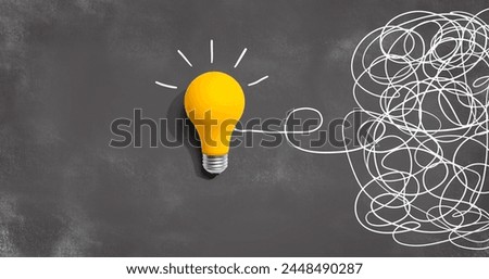 Clarifying complex ideas theme with light bulb - Flat lay Royalty-Free Stock Photo #2448490287