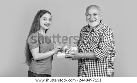 happy girl and granddad with present box for anniversary