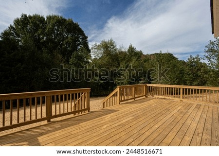 Spacious New Construction Wooden Deck, Serene Backyard with Trees and Open Sky, Fresh Dirt Royalty-Free Stock Photo #2448516671