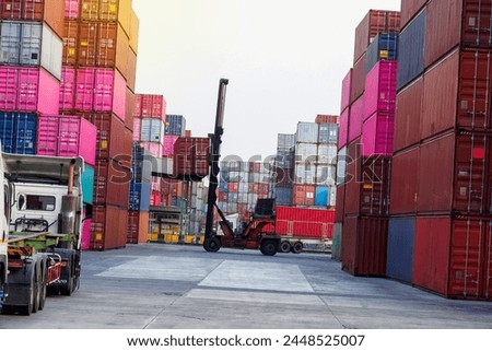 Transporting goods via container lift trucks plays a crucial role in global logistics for both exporting and distributing goods worldwide. Royalty-Free Stock Photo #2448525007