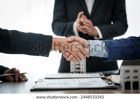 Two individuals shake hands in agreement after a successful business meeting with a condominium seller, finalizing a deal or partnership.