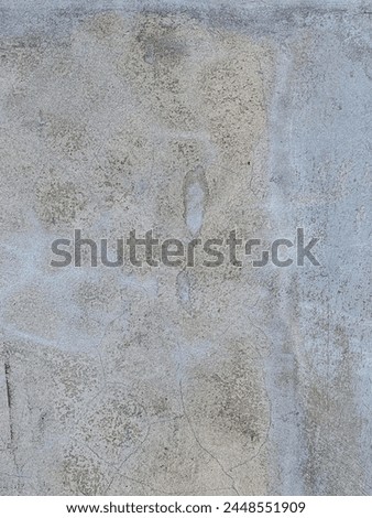 a photography of a fire hydrant sitting on the side of a cement wall.