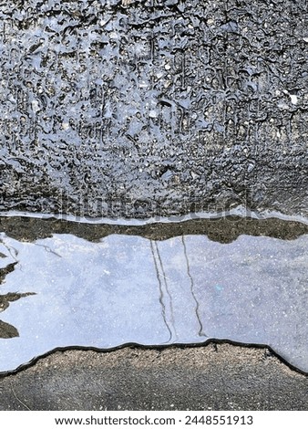 a photography of a puddle of water on the ground next to a fire hydrant.