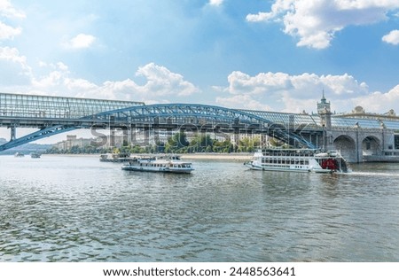 View of the Moscow river embakment, Pushkinsky bridge and cruise ships at sunset. Wide Moskva River, Pushkinsky bridge, Groky Park, Frunzenskaya embankment, Royalty-Free Stock Photo #2448563641