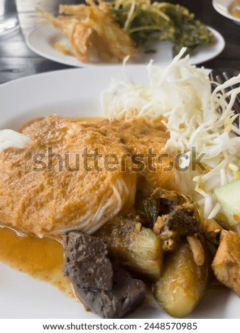 Rice noodles in fish curry sauce with meatball and vegetable, stock photo