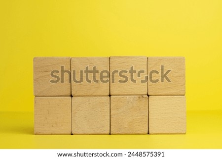 Blank eight Wooden cubes stack in two row for put text,logo and infographic on center photo over yellow background with copyspace.
