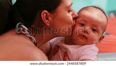 Mother kissing newborn baby showing love and affection