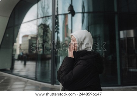 Upset and depressed girl holding smartphone and holding head. University sad student suffering from depression at high school. Lonely bullied teen. Royalty-Free Stock Photo #2448596147
