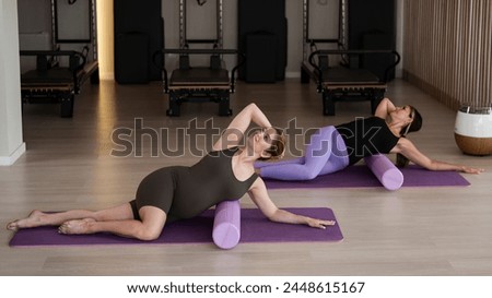 Two pregnant women doing yoga. Preparing for the birth of a child. 